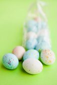 Pastel-coloured Easter eggs, some in cellophane bag