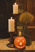 Herbstliche Deko: Kerzen, Ährenstrauss und Kürbislaterne