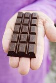 Hand holding a bar of chocolate