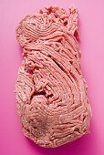 Frisches Hackfleisch auf pinkfarbenem Untergrund