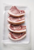 Four raw pork chops on paper