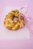 Plaited bread ring with pearl sugar and pink bow