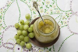 Jar of gooseberry jam and fresh gooseberries