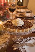 Pecan pie with cream on table laid for Thanksgiving (USA)