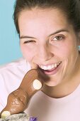 Frau beisst in Schokoladenosterhasen
