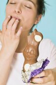 Woman holding chocolate Easter Bunny with a bite taken