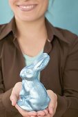 Woman holding chocolate Easter Bunny wrapped in foil