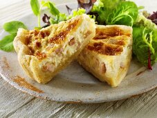 Two pieces of quiche Lorraine with salad leaves