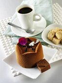 Small chocolate cake, cup of coffee and sugar cubes