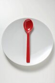 Red spoon on white plate