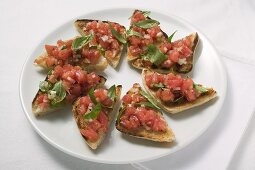 Bruschetta mit Tomatensalsa und Basilikum auf Teller