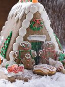 Weihnachtliches Lebkuchenhaus mit Zucker bestreuen