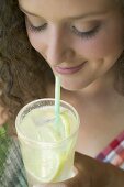 Young woman drinking lemonade through a straw