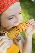 Woman eating grilled corn on the cob