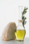 Olivenöl in Karaffe, daneben Stück Weißbrot