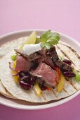 Beef fajita with beans, peppers and sour cream