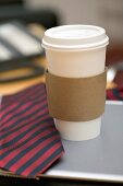Coffee cup and tie on desk in office