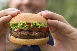 Man holding large hamburger