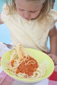 Kleines Mädchen isst Spaghetti mit Tomatensauce