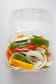 Sliced vegetables in opened plastic container (overhead)