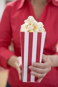 Woman holding popcorn in striped box (4th of July, USA)