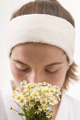 Woman smelling chamomile flowers