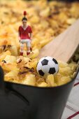 Cheese & onion pasta bake, football figure & football (detail)