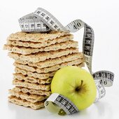 Crispbread, in a pile, and apple with tape measure