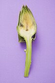 Half an artichoke on purple background