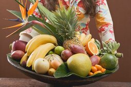 Woman holding bowl of exotic fruit