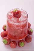 Fruity strawberry drink, surrounded by fresh strawberries