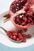 Half a pomegranate and spoonful of pomegranate seeds