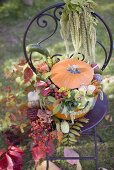 Pumpkin decorated with flowers on garden chair