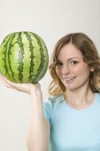 Frau hält Wassermelone mit einer Hand