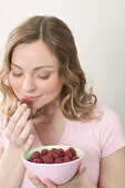 Woman smelling fresh raspberry