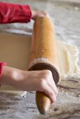 Child's hands rolling out biscuit dough