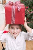 Girl balancing Christmas gift on her head