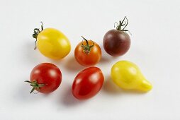Tomatoes of various colours on white background