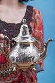 Frau hält orientalische Teekanne