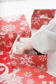 Child's hand taking Christmas tree ornament out of box