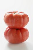 Two beefsteak tomatoes, one on top of the other
