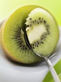 Spooning the flesh out of a kiwi fruit