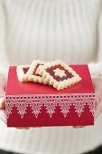 Woman holding jam biscuits on red box