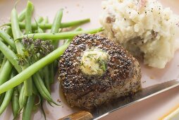 Peppered steak with herb butter, beans and mashed potato