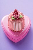 Marzipan-covered cake on pink chocolate box