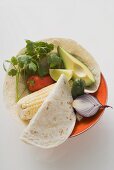 Zutaten für mexikanische Gerichte auf Teller (Draufsicht)