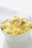 Mashed potato with butter in bowl and on spoon