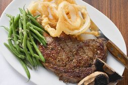 Ribeye Steak mit grünen Bohnen und frittierten Zwiebelringen