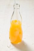 Orange juice in bottle with straw