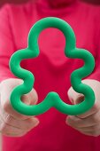 Woman holding gingerbread man cutter